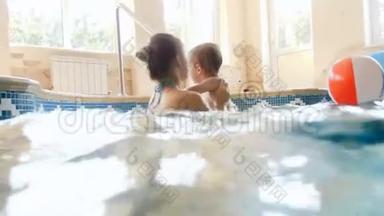 4k镜头，快乐的年轻母亲和蹒跚学步的男孩在体育馆的游泳池里玩耍和享受游泳